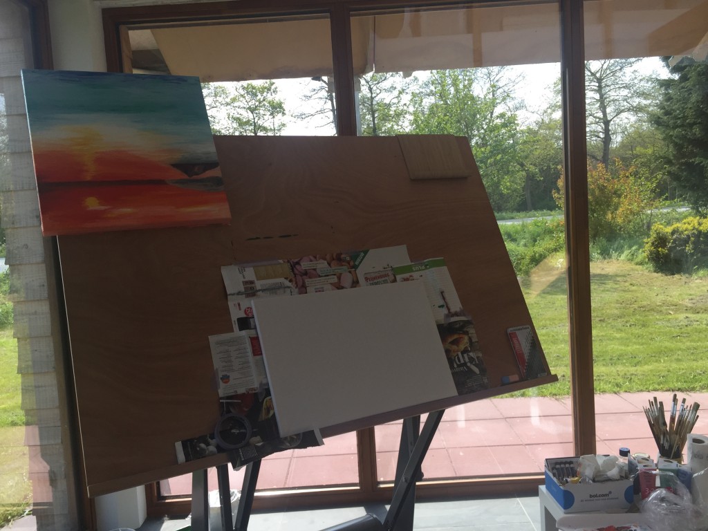 Schilderij van een tropische zonsondergang hangt ondersteboven te drogen